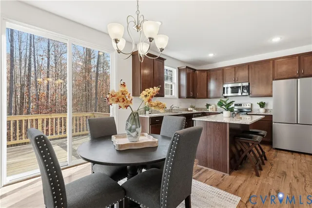 a view of a dining room with furniture a chandelier and wooden floor