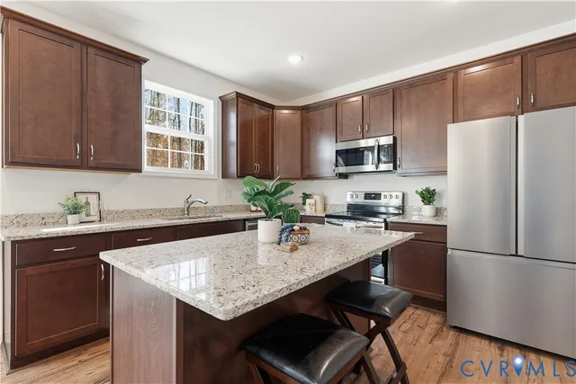 a kitchen with stainless steel appliances granite countertop a stove refrigerator sink and cabinets