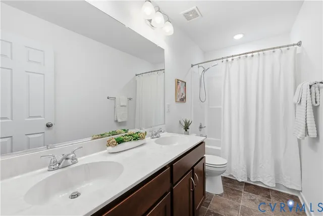 a bathroom with a double vanity sink mirror and toilet