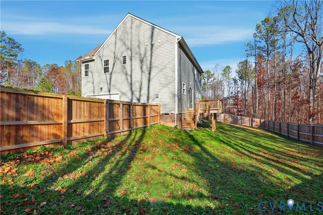 a view of an apartment with a large yard and large trees