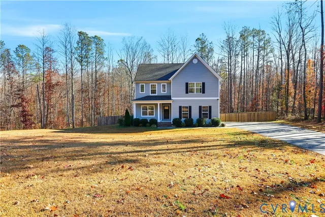 a front view of a house with a yard and ocean view