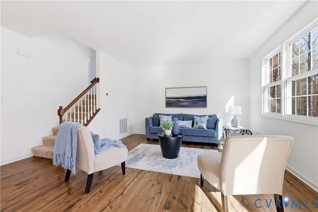a living room with furniture and a wooden floor
