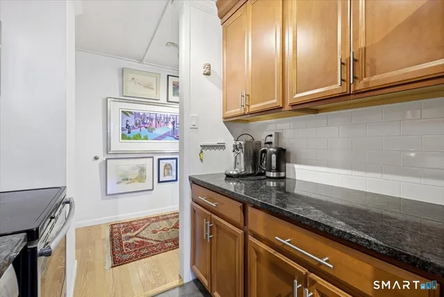 a kitchen with stainless steel appliances granite countertop a sink a stove and cabinets