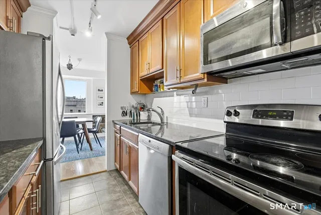 a kitchen with stainless steel appliances granite countertop a stove and a refrigerator