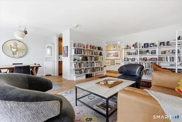 a living room with furniture a rug and a book shelf