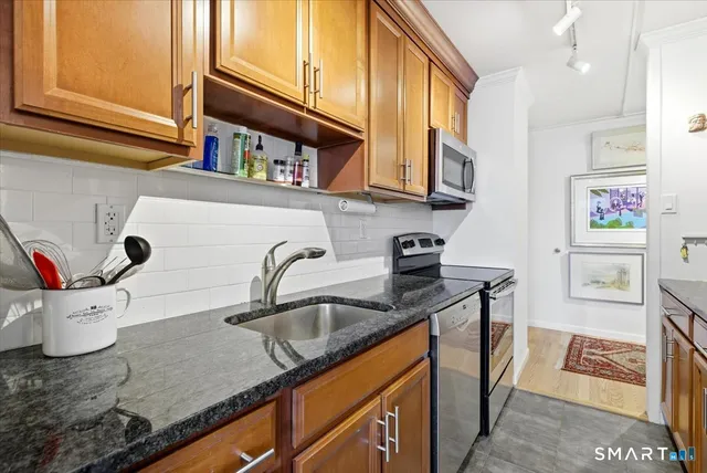 a kitchen with stainless steel appliances granite countertop a sink a stove and a microwave