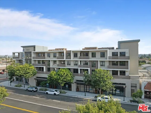 a view of a building and bench next to a road