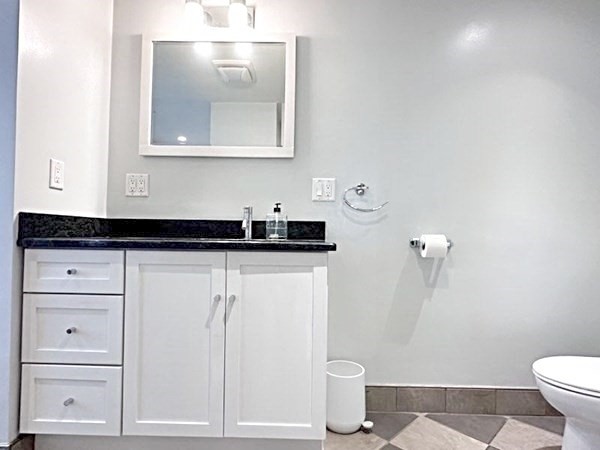 35 Parham Road Tyngsboro, MA 01879 - Photo 16 of 42 a bathroom with a granite countertop sink a toilet and a mirror