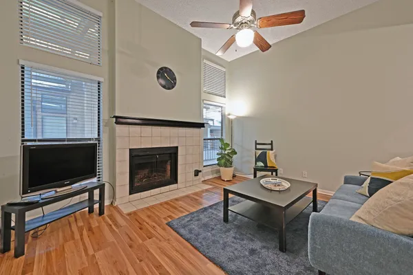 a living room with furniture a flat screen tv and a fireplace