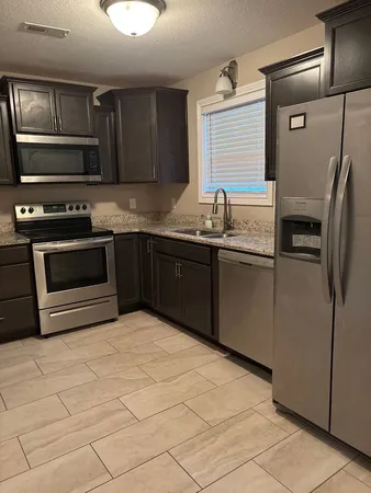 a kitchen with stainless steel appliances granite countertop a sink and a stove