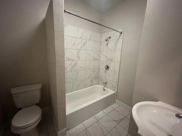 a white toilet sitting next to a bath tub