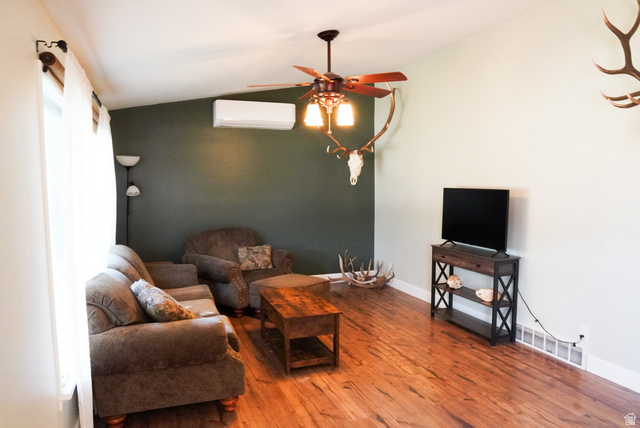 324 Stringtown Road Georgetown, ID 83239 - Photo 5 of 49 Living area featuring lofted ceiling, wood finished floors, a ceiling fan, and a wall mounted air conditioner