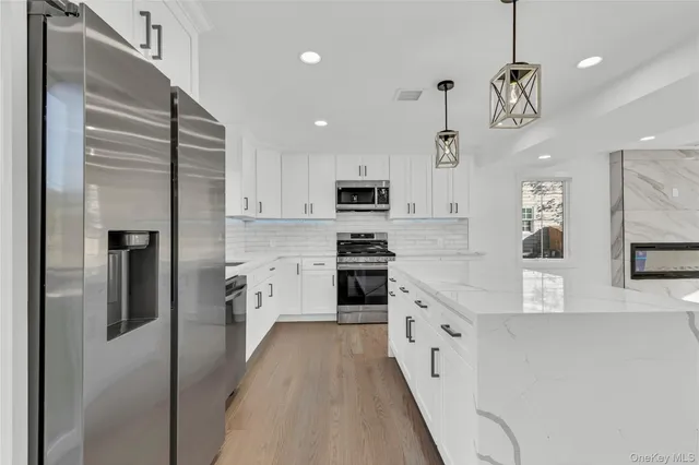 a kitchen with white cabinets and stainless steel appliances