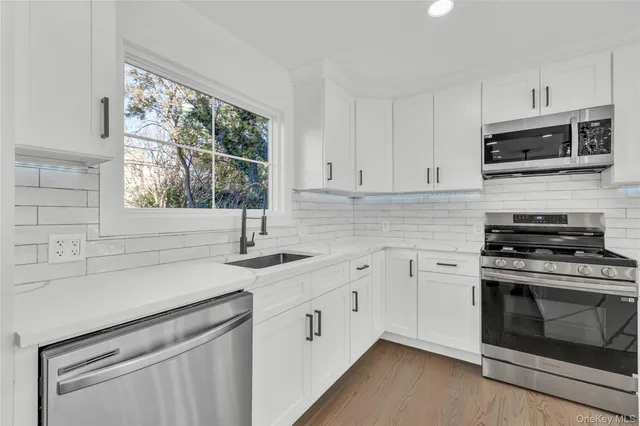 a kitchen with stainless steel appliances white cabinets and a sink