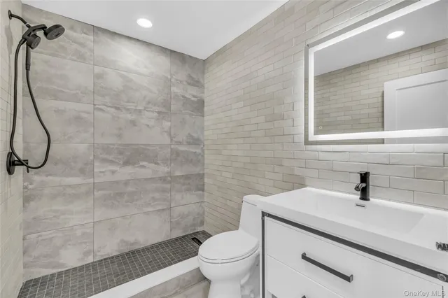 a view of kitchen with stainless steel appliances granite countertop a stove top oven a refrigerator and white cabinets with wooden floor