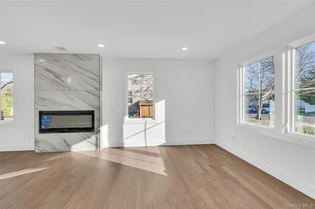 a view of empty room with wooden floor and fireplace