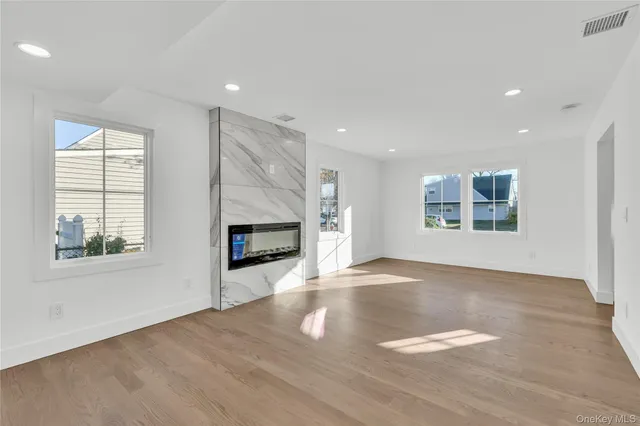 an empty room with windows and fireplace