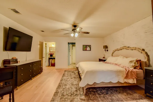 a spacious bedroom with a bed and a flat screen tv