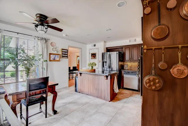 a kitchen with stainless steel appliances granite countertop a refrigerator and a stove top oven