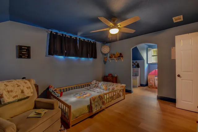 a bedroom with a bed and a ceiling fan