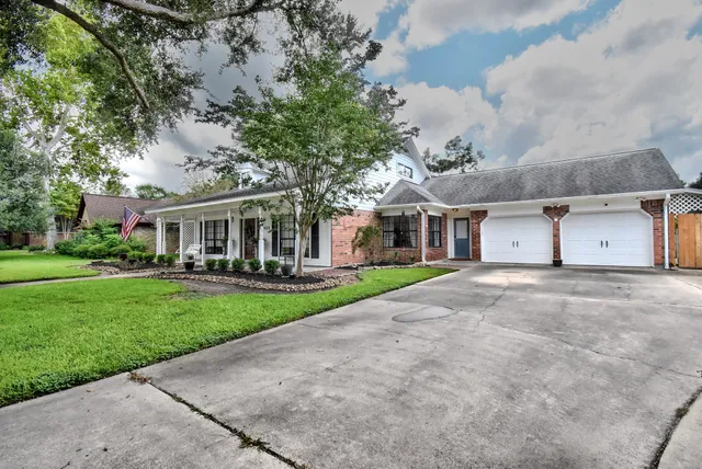 front view of a house with a yard and an trees
