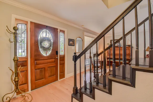 a view of staircase with wooden floor and a mirror