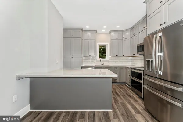a kitchen with kitchen island a sink stainless steel appliances and cabinets
