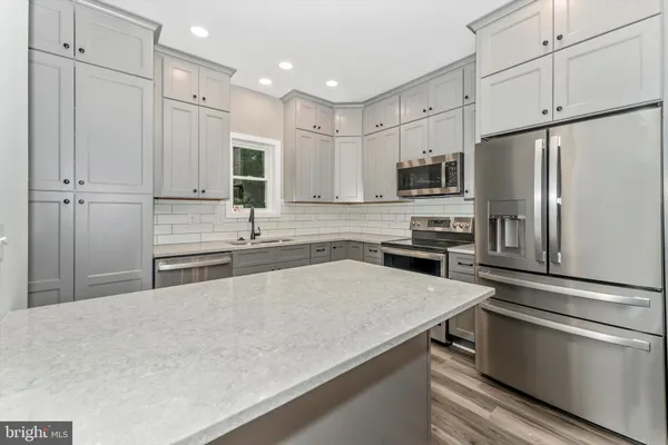 a kitchen with stainless steel appliances a refrigerator sink and microwave
