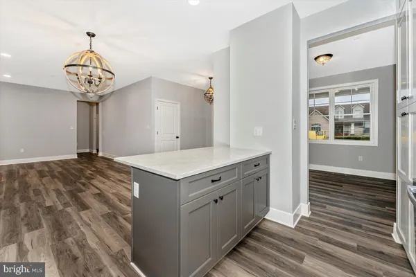 a kitchen with a stove and wooden floor