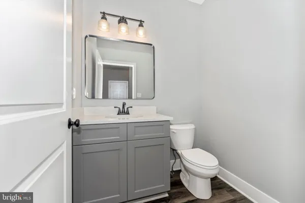 a bathroom with a toilet a sink and mirror