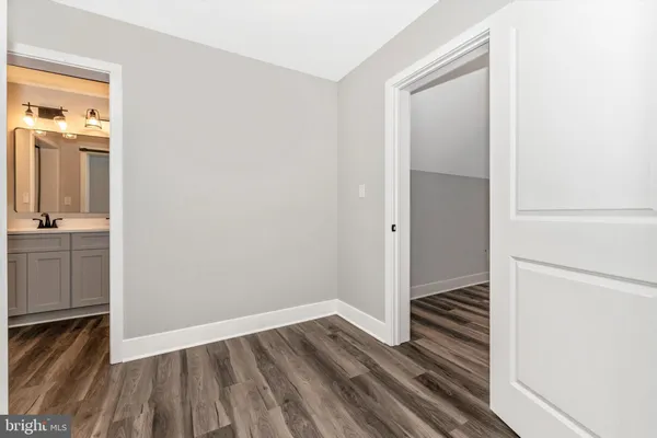 a view of a room with wooden floor and a hallway