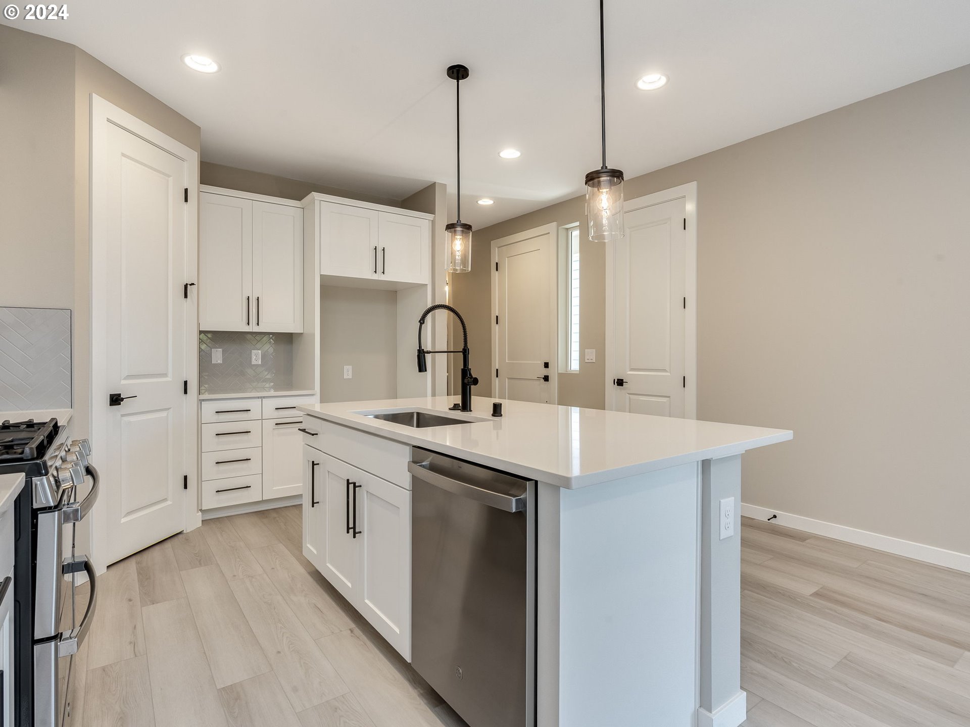 850 Northwest 178th Street Ridgefield, WA 98642 - Photo 8 of 48 a kitchen with white cabinets appliances and a wooden floor