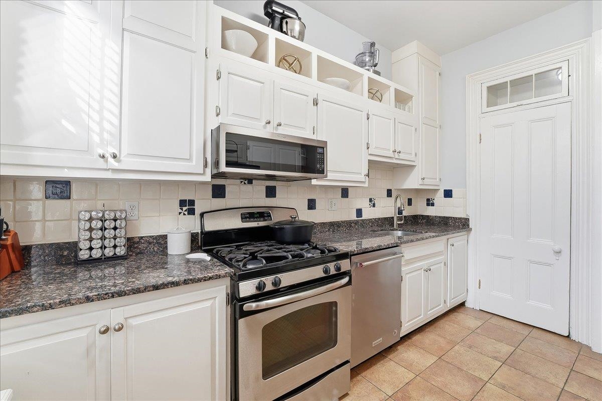 826 Washington Street, Unit 2 Hoboken, NJ 07030 - Photo 30 of 42 a kitchen with granite countertop white cabinets sink and stainless steel appliances