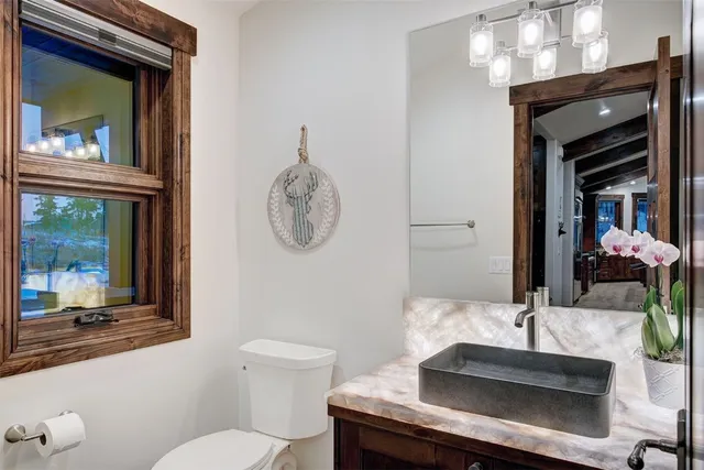 a bathroom with a toilet a sink and mirror