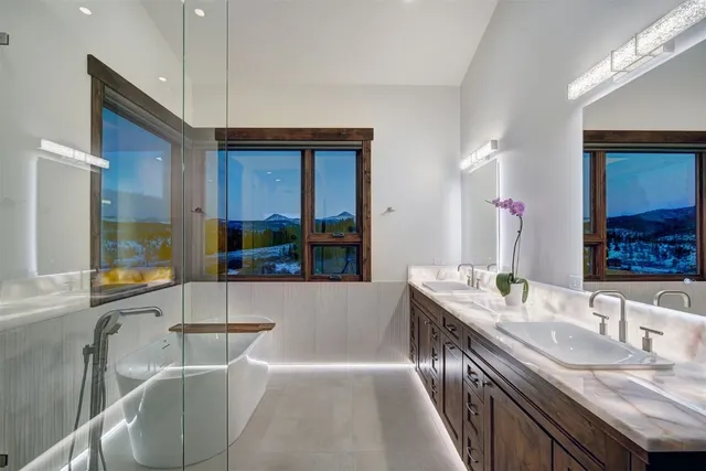 a bathroom with a granite countertop tub sink and mirror