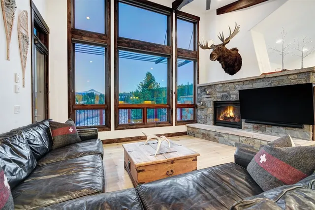 a living room with furniture a fireplace and a floor to ceiling window