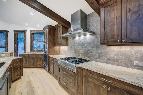a kitchen with stainless steel appliances granite countertop a stove and a sink