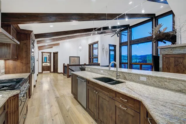 a kitchen with stainless steel appliances granite countertop a sink and a stove