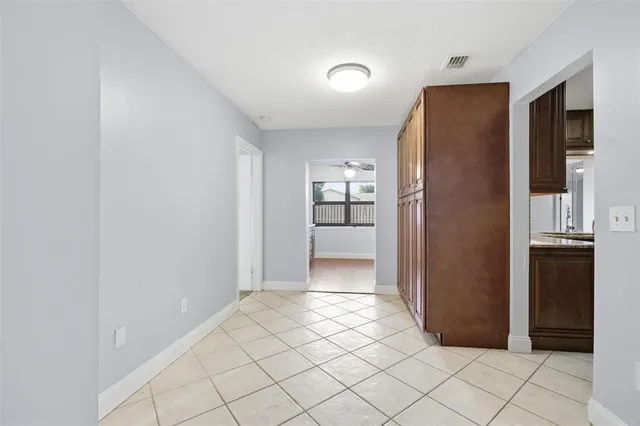 a view of a refrigerator in kitchen and an empty room