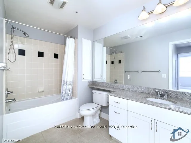 a bathroom with a granite countertop sink a toilet a mirror and shower