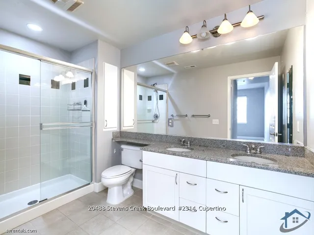 a bathroom with a granite countertop sink a toilet and a mirror