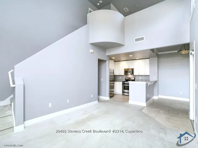 a open kitchen with cabinets and a stainless steel refrigerator
