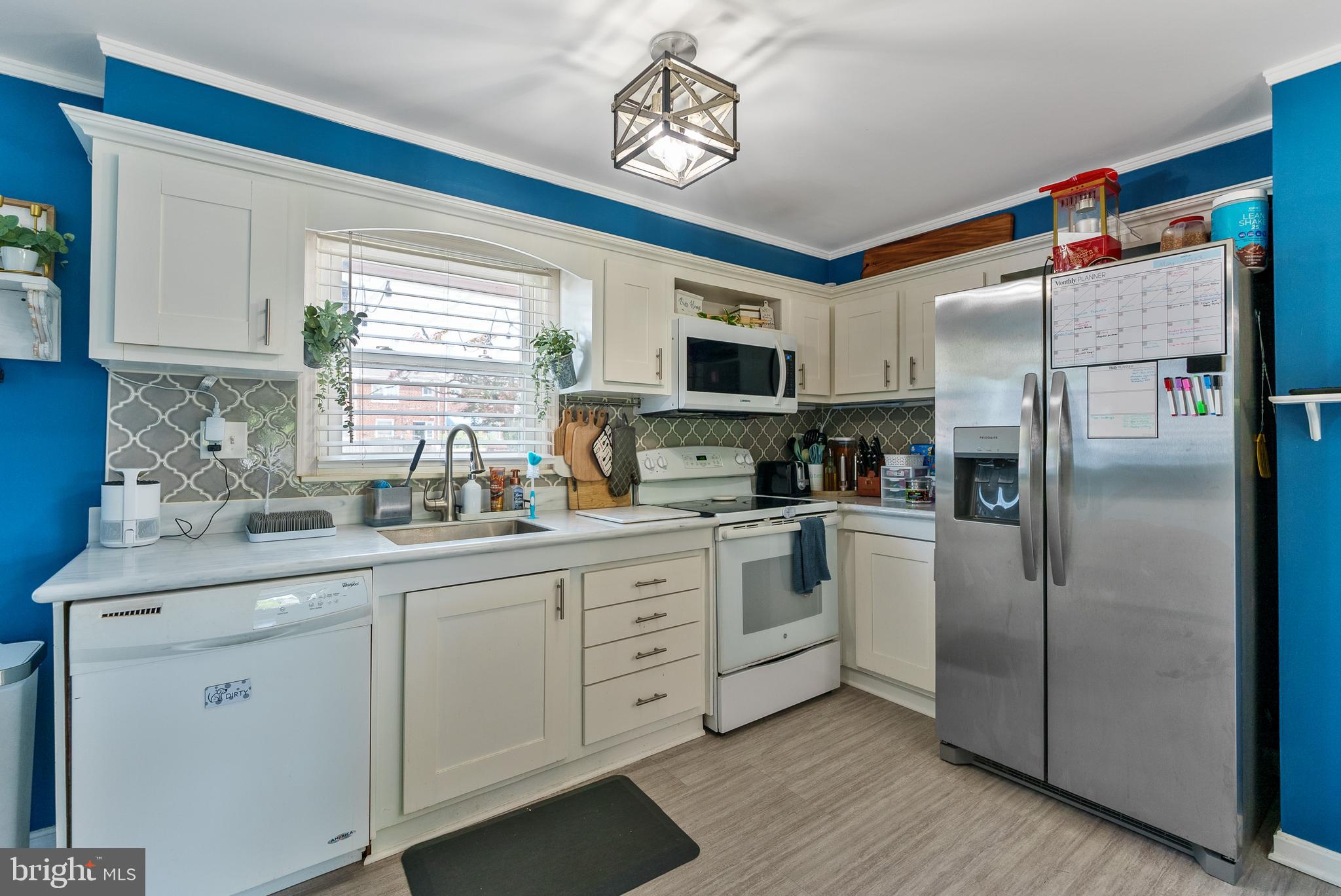 5633 Chelwynd Road Halethorpe, MD 21227 - Photo 18 of 41 a kitchen with white cabinets stainless steel appliances and a window