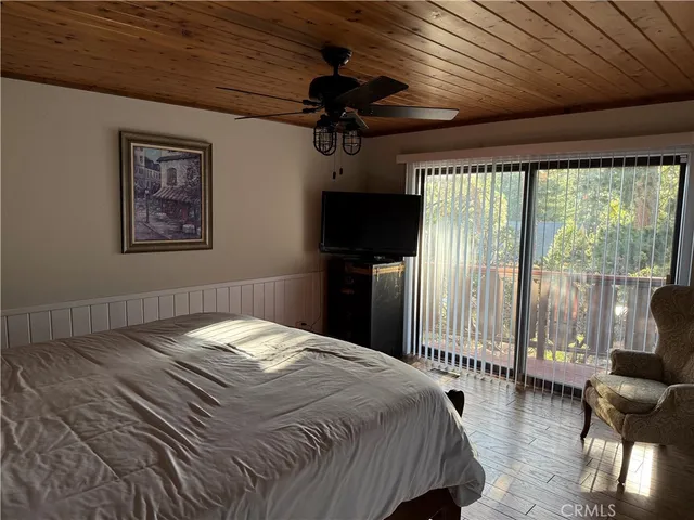 a bedroom with a bed a couch and a large window