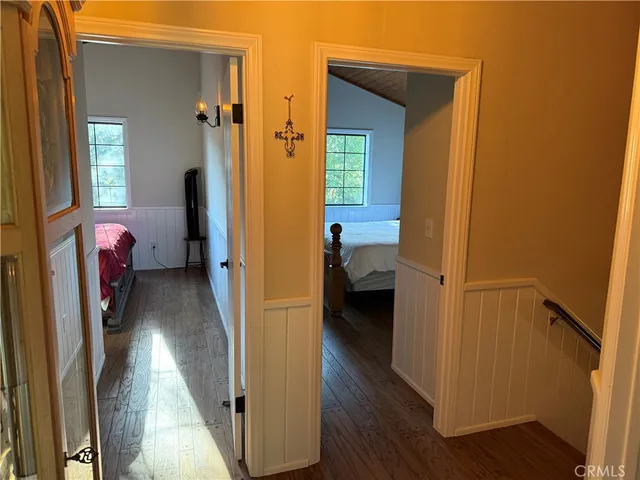 a view of a bedroom with a bed and wooden floor