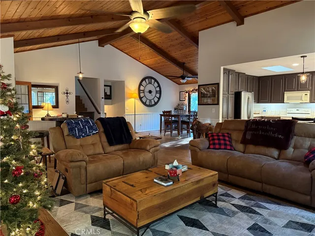 a living room with furniture a clock on wall and a window