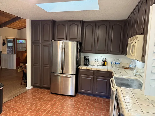 a kitchen with stainless steel appliances granite countertop a refrigerator and a stove top oven