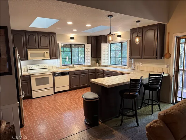 a kitchen with stainless steel appliances granite countertop table chairs sink and cabinets