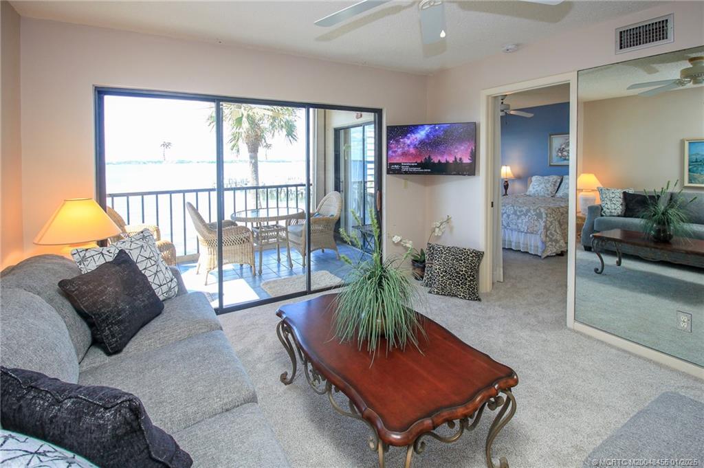 4540 Northeast Sandpebble Trace, Unit 302 Stuart, FL 34996 - Photo 11 of 34 a living room with furniture and a potted plant