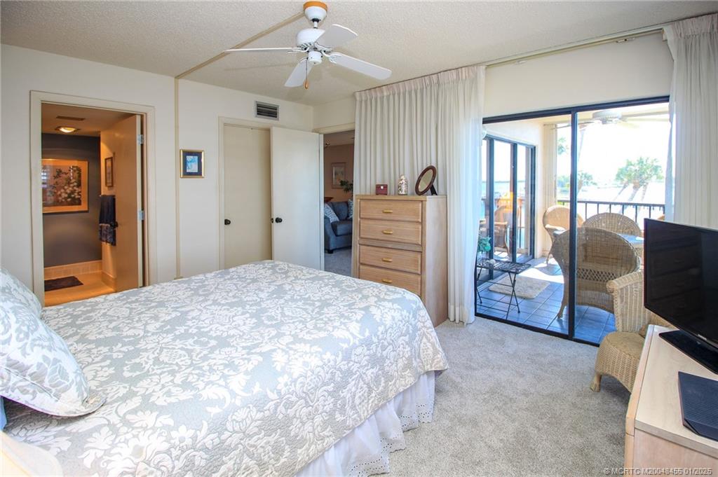 4540 Northeast Sandpebble Trace, Unit 302 Stuart, FL 34996 - Photo 16 of 34 a bedroom with a bed and wooden floor